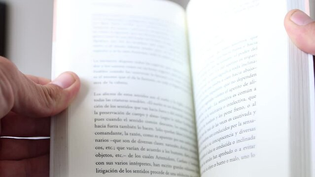 hand holding a book. pages goes slow at first and then faster. spanish text