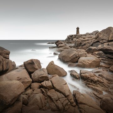 Long exposure of the Phare de Ploumanach lighthouse on the rugged coast of Brittany, France, Europe