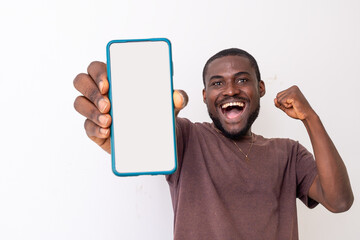 African american guy holding big smartphone with white blank screen in hand,
