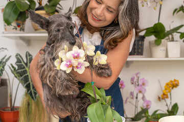 Woman caressing a dog taking a break of arranging plants