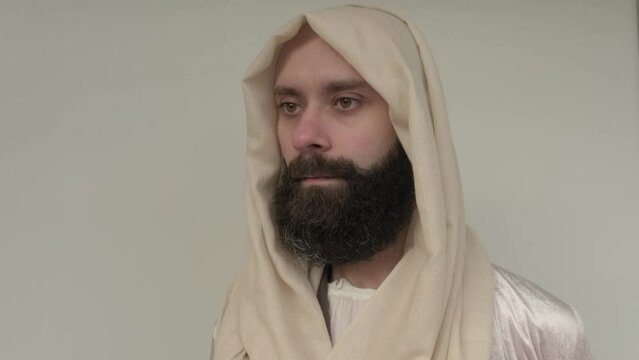 biblical scene, Jesus Christ, young pensive bearded man, guy 30 years in white light vestment, beige cape stands in image of Savior, concept of Holy Scriptures of Old and New Testaments