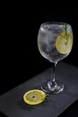 refreshing alcoholic drink with berries, ice vodka and gin, lemon peel served in glass cup on the counter on blurred background