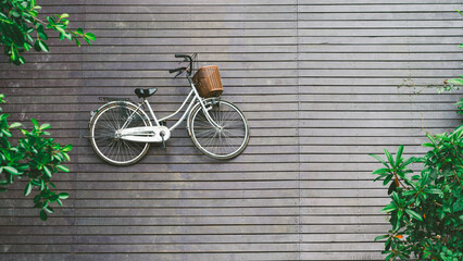 The bicycle lying on wooden floor with trees along the way from top view.