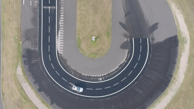 Aerial top down view of car drive sharp turn on weather simulation track
