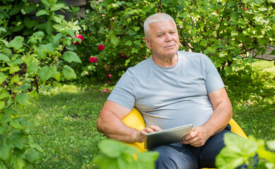 confident elderly man with tablet