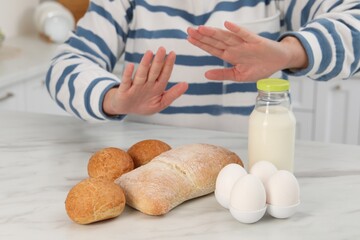 Woman suffering from food allergies refusing eat different fresh products at light marble table...