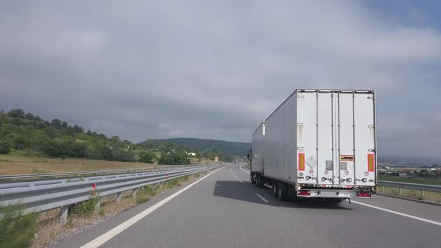 Long white truck with trailer drive shipping goods on highway, cinematic shot