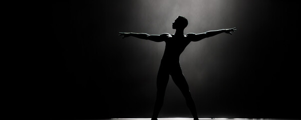 Silhouette of a male dancer performing an elegant mid-air leap on a dark stage with a dramatic spotlight.