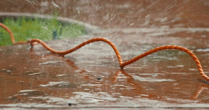 Orange extension cord outside in the rain 
