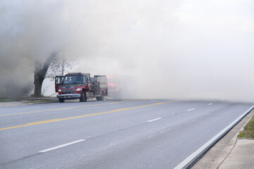 Red fire truck in dense shroud of smoke