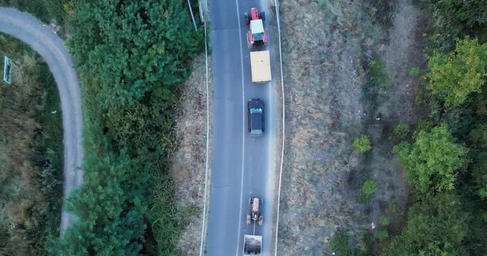 Agricultural tractor trailer transporting maise to farm, aerial drone view