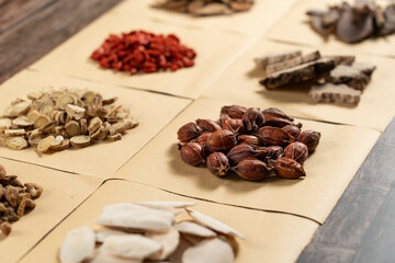 Ancient Chinese medicine and different herbal ingredients on table.