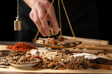 Ancient Chinese medicine and different herbal ingredients on table.