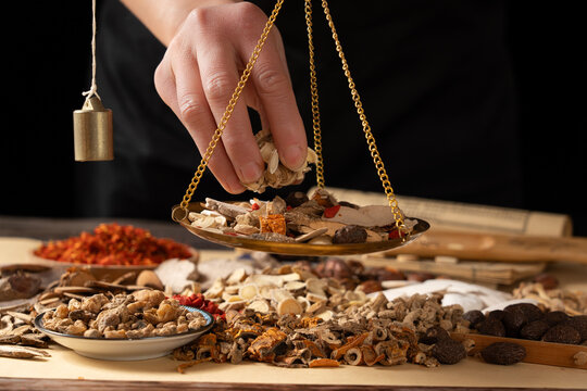Ancient Chinese medicine and different herbal ingredients on table.