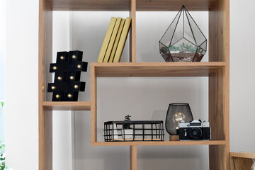 Shelving unit with glowing lamps, books and decor in room