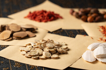 Ancient Chinese medicine and different herbal ingredients on table.