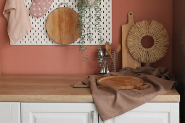 Wooden kitchen counter with cutting boards, towel and utensils