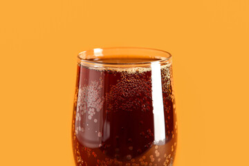 Glass of tasty kvass on orange background