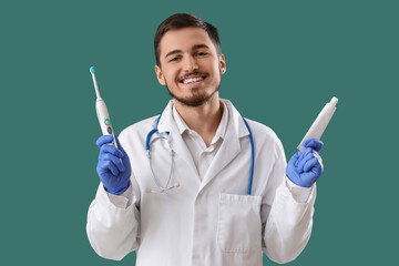 Handsome young man with electric tooth brush and paste on green background. Dental care concept