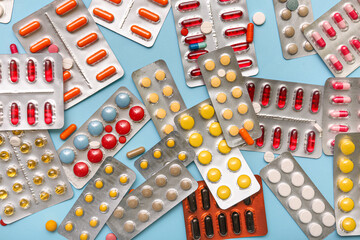 Blister packs with different pills on blue background