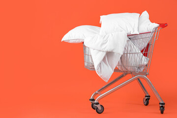 Shopping cart full of pillows on orange background