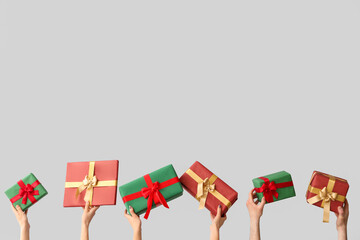 Female hands holding Christmas gift boxes on white background