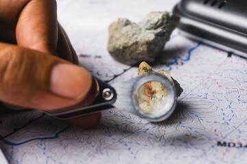 geologist using a loupe for rock and mineral identification and description