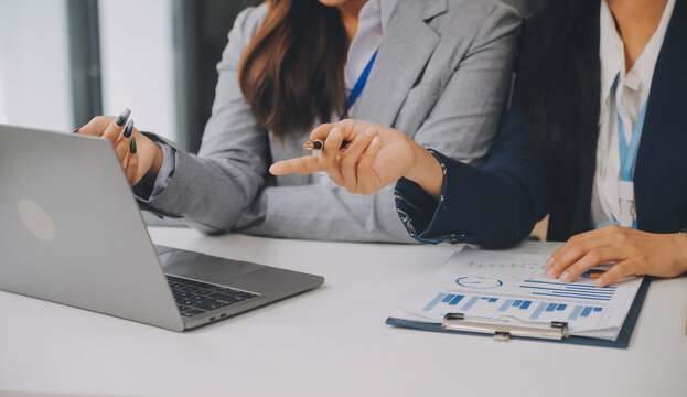 Business team two colleagues discussing new plan financial graph data on office table with laptop and digital tablet.