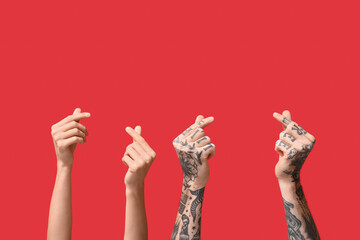 Woman and man making heart with fingers on red background