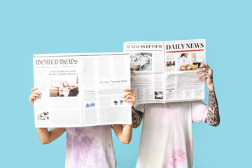 Couple with newspapers on blue background