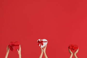 Women with gift boxes on red background. Valentine's Day celebration