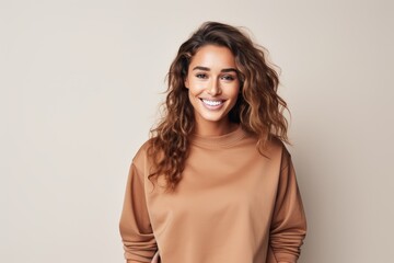 Obraz premium A smiling woman in a tan sweater