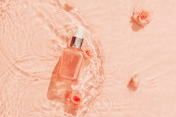 Cosmetics on water background of trendy peach colour. Hyaluronic acid skin care for youthful skin.