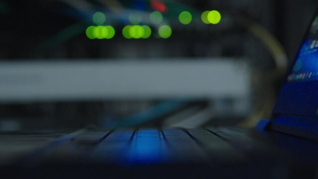 Close up, Keyboard of laptop in server room. Light and line for data information it working.