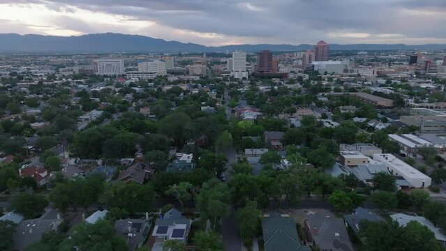 Wide panoramic view of Albuquerque, New Mexico skyline and housing. Aerial reveal during sunrise.