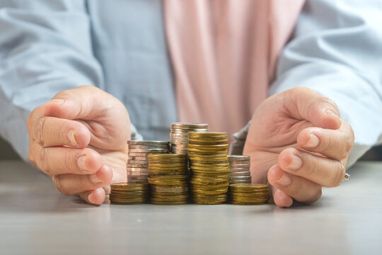 muslim businesswoman hand protect heap of coins money symbol for sharia financial banking investment dividend from business growth concept.