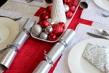 A table laid for Christmas dinner in red, silver and white