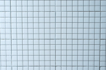 White concrete tile wall in square ceramic pattern. White tiles wall texture