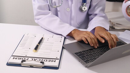 Initial AI illustration of a close-up of a female doctor's hand signing a medical document on a clipboard. and recommending certain medicines to patients on a laptop