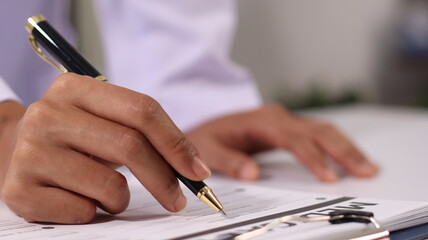 Initial AI illustration of a close-up of a female doctor's hand signing a medical document on a...