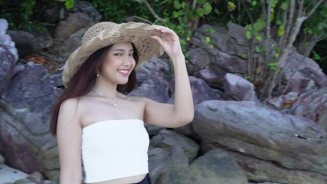 Woman in a white tube top walks along the Bobby beach in Karimunjawa towards the sea