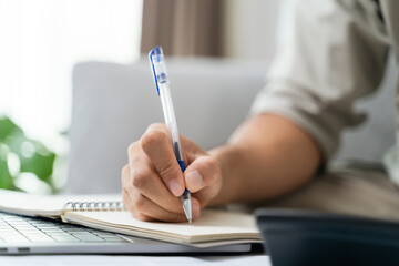 Man is calculating annual tax with calculator and filling form of Individual Income Tax Return....