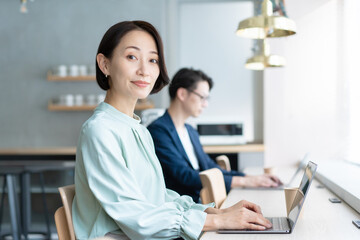 カフェでパソコンを使う男女