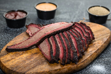 Beef Brisket platter steak meat sliced isolated on wooden board with dip sauce top view of grill...
