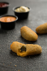 Jalapeno Poppers with dip sauce isolated on dark grey background side view of fast food sandwich