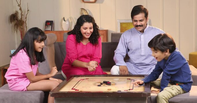 Video of Happy family playing carrom together at home

