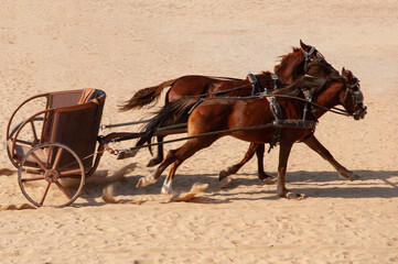 Jordan. Jerash. Chariot drawn by two horses without charioteer rushes along hippodrome of ancient...