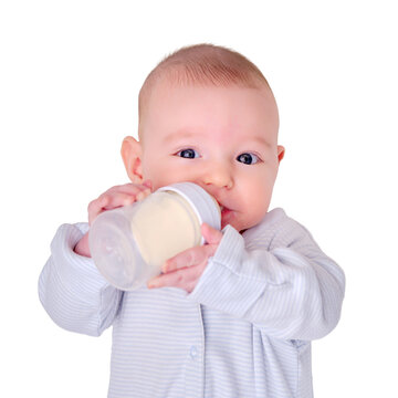 Happy baby is smiling on her own holding a bottle of milk in her hands, isolated on a white background. Three month old child keeps the mixture himself lying in bed