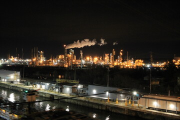 Fototapeta na wymiar night view of a petroleum refining plant and a canal