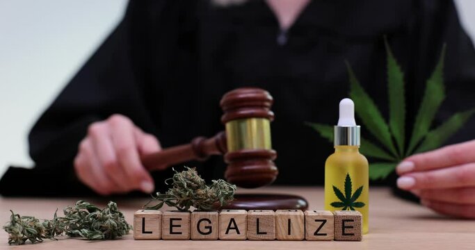 Word legalization on wooden cubes on background of marijuana and judge with gavel 4k movie slow motion.